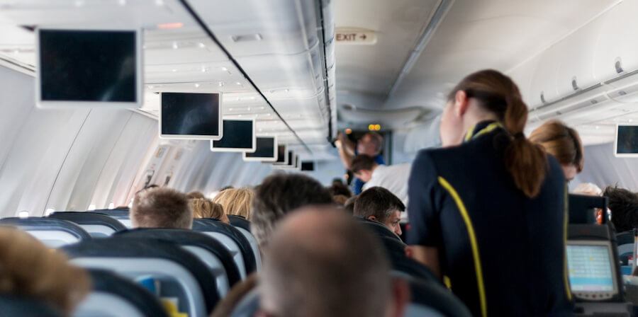 A flight attendant tends to passengers on an aircraft.
