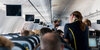Thumbnail image: A flight attendant tends to passengers on an aircraft.