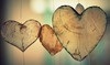 Thumbnail image: Wires suspend three wooden ornamental heart shapes.